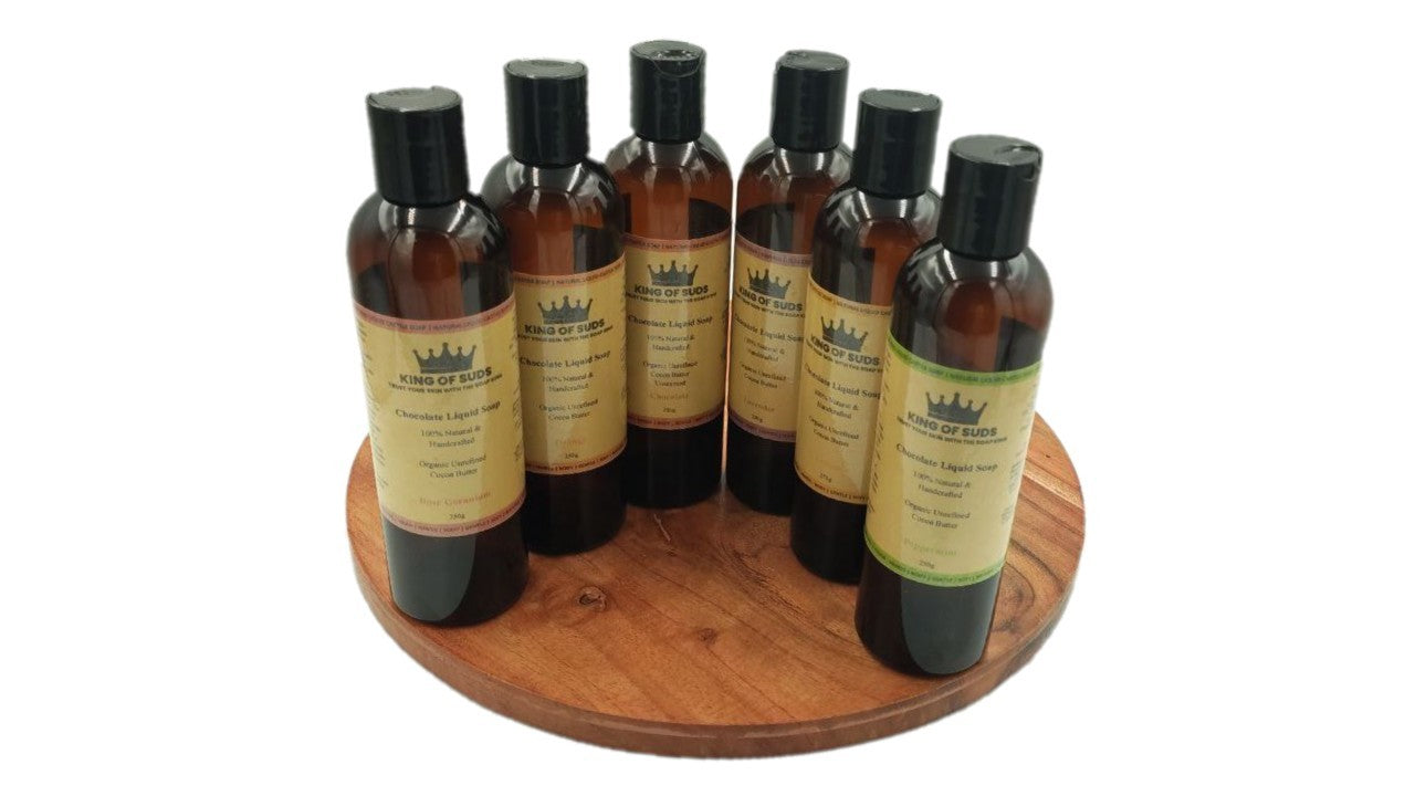 Set of six bottles with labels on a wooden tray against a white background