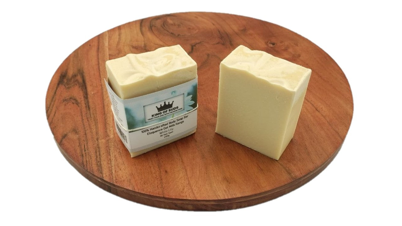Two blocks of soap on a wooden cutting board with a visible brand label.
