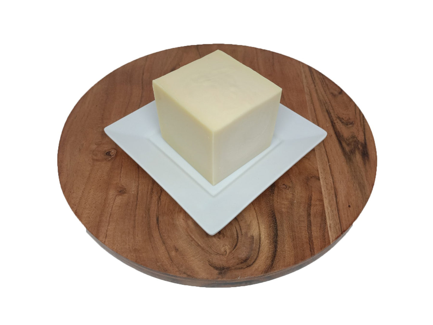 A square white plate on a round wooden surface, likely a dish washing block holder.