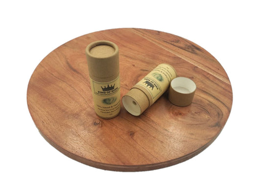 Two cardboard tubes balms with branding on a wooden surface