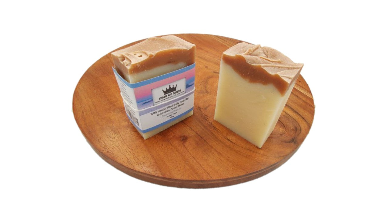 Two bars of soap on a wooden board with a white background