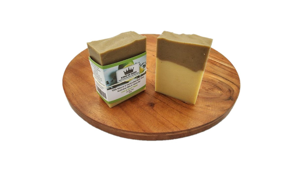 Two bars of soap on a wooden board with a white background