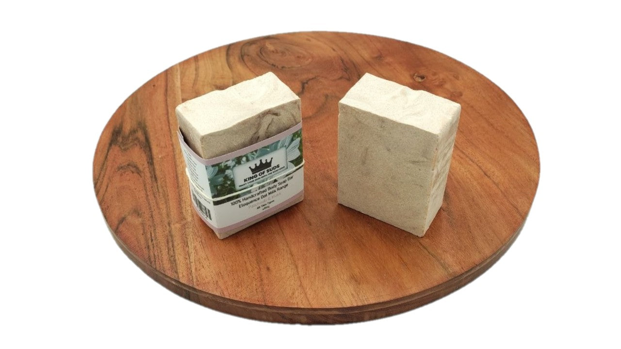 Two bars of soap on a wooden surface with a white background