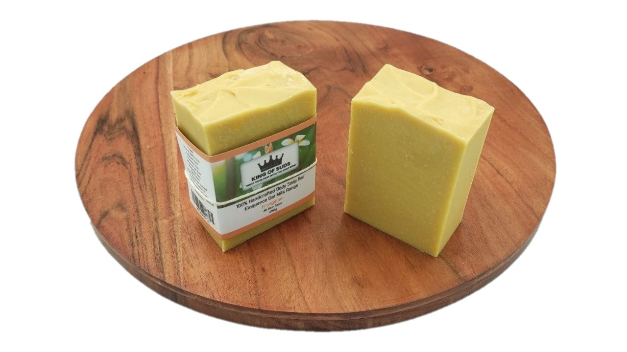 Two bars of soap on a wooden turntable with a white background