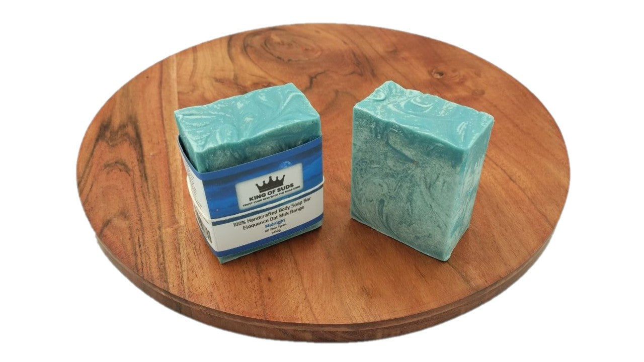 Two bars of soap on a wooden turntable with a white background