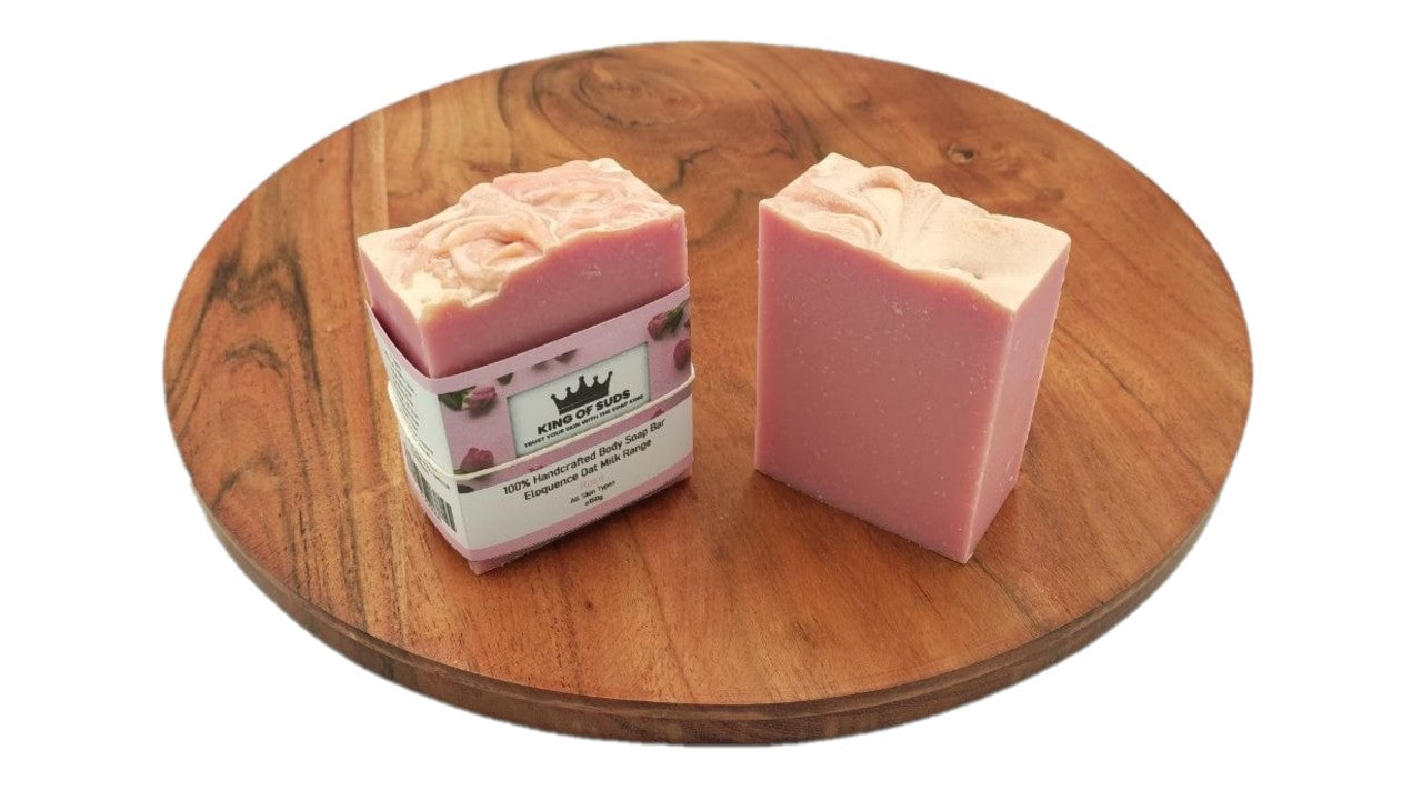 Two pink soap bars on a wooden surface with a visible brand label.