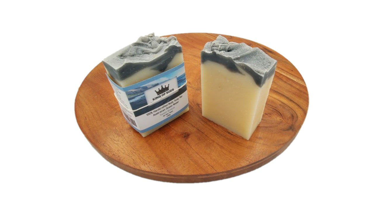 Two bars of soap on a wooden board with a white background