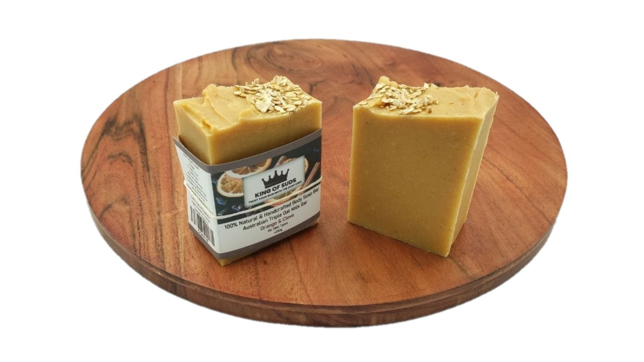 Two bars of soap on a wooden tray with a white background