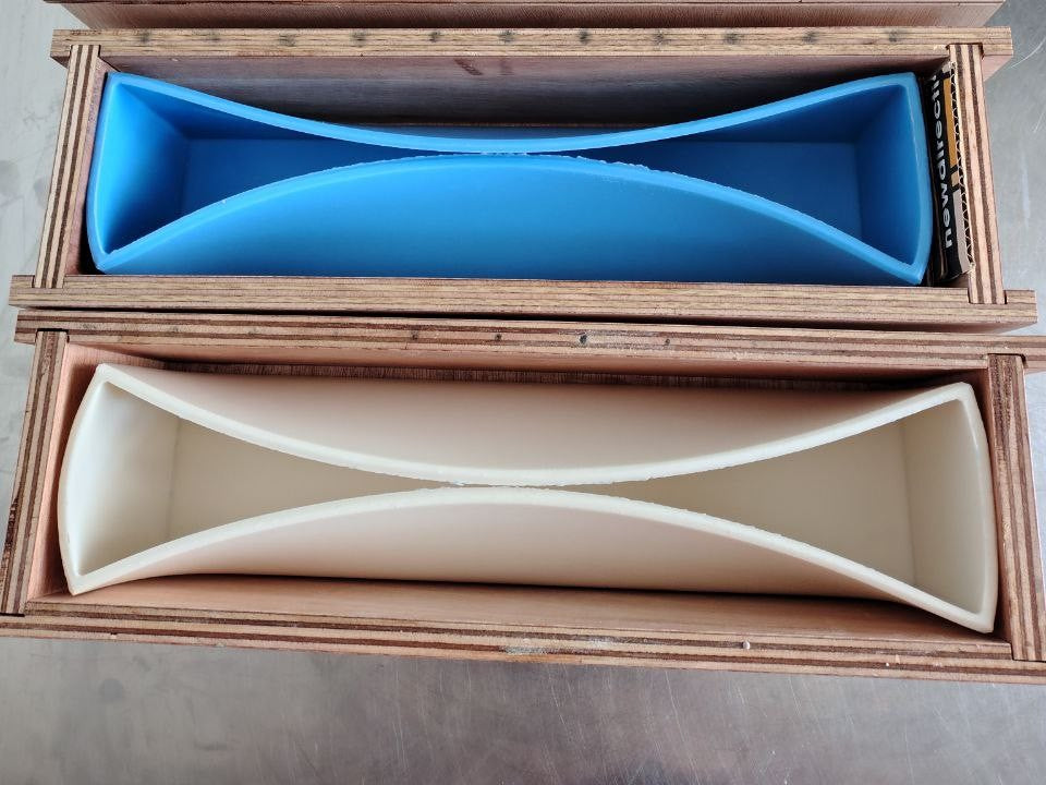 Two wooden boxes with blue and beige interior compartments on a wooden surface.